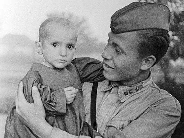Một chiến sĩ Hồng quân bế trên tay em bé mà anh vừa cứu sống ở làng Elkhontovo năm 1942.