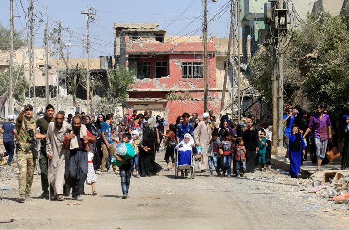 Binh sĩ Iraq hướng dẫn cư dân Tây Mosul vừa chạy khỏi khu vực có chiến sự ở Tây Mosul. Ảnh: REUTERS