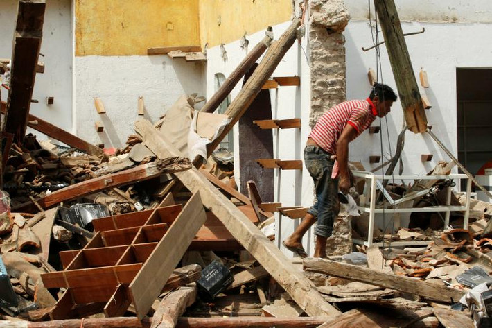 Một cư dân khác tìm kiếm đồ đạc trong ngôi nhà bị đổ sập. Ảnh: REUTERS