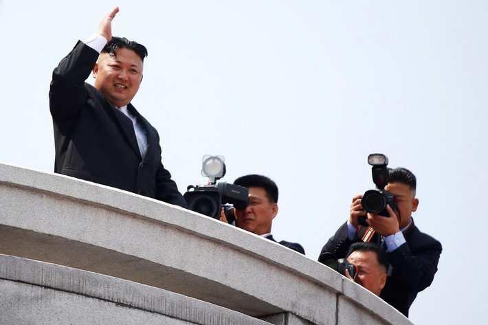 Theo truyền thống, nhà lãnh đạo Triều Tiên Kim Jong-un đứng trên lễ đài vẫy tay chào đoàn người diễu hành trên Quảng trường Kim Il-sung. Ảnh: Reuters