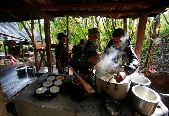 Trong ảnh: Thành viên Mặt trận 51 chuẩn bị bữa ăn tại lán trại ở Cordillera Oriental. Ảnh REUTERS