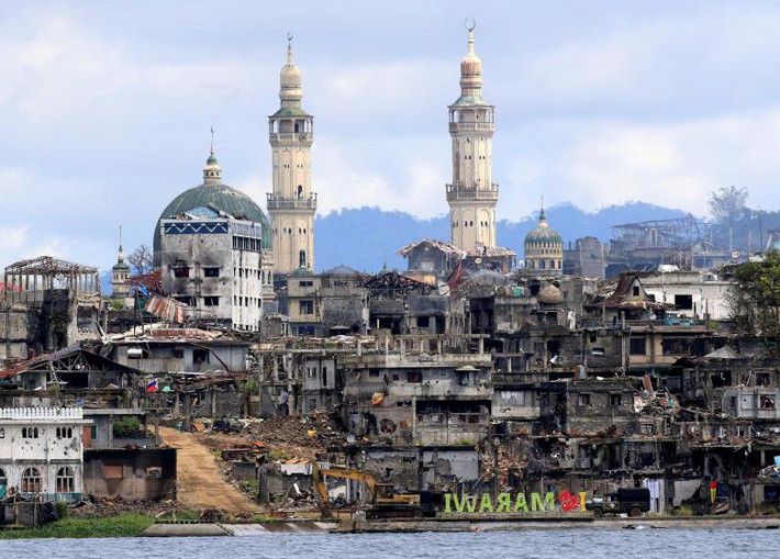 Một khẩu hiệu "Tôi yêu Marawi" được nhìn thấy trước những ngôi nhà trơ bộ xương thép đúc và những đống đổ nát ở thành phố Marawi bị chiến tranh tàn phá nặng nề. Ảnh: REUTERS