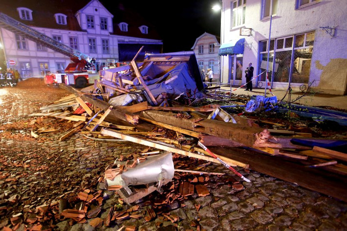 Đường phố Bützow trông giống như một bãi chiến trường. Schwere Schäden im ganzen Ort - ein Auto landete in Bützow auf dem Dach. Augenzeugen sprechen danach von einem Tornado, der den Ort verwüstet habe. Kirche und Rathaus wurden schwer beschädigt, das Krankenhaus musste teilweise geräumt werden. (10) Der Sturm deckte unzählige Dächer ab, unter anderem wurden das Krankenhaus und eine Kirche in Bützow beschädigt. (11) Mit Traktoren werden die Trümmer zusammengeschoben. Mehr als hundert Rettungskräfte sind in dem 7800-Einwohner-Ort im Einsatz. (12) Die Behörden haben Katastrophenalarm ausgelöst. Das Stadtgebiet bleibt bis zum Montagmorgen gesperrt. (13)