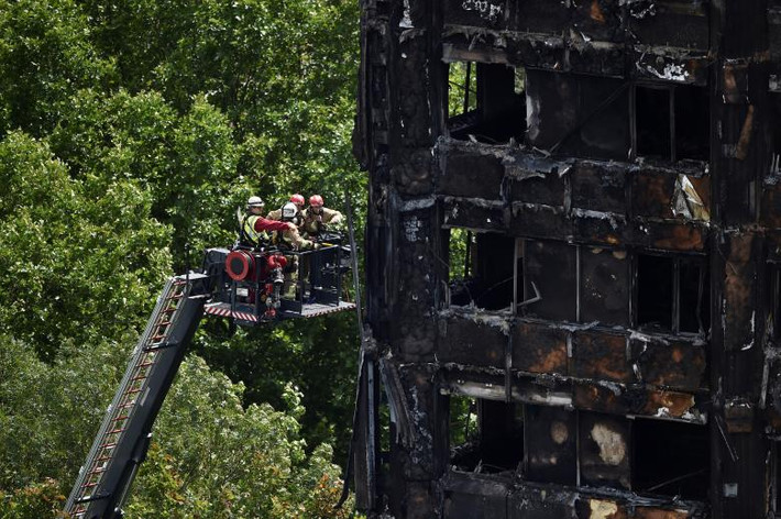 Lính cứu hỏa tại chung cư cao tầng Grenfell Tower bị cháy rụi. Ảnh: REUTERS