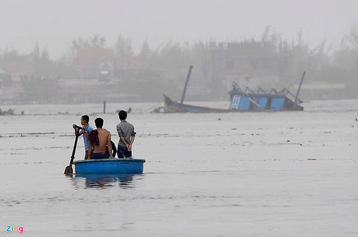 Sau khi gió lặng, người dân ở âu tàu Thanh Khê phát hiện một con tàu bị đắm. Họ đi thuyền thúng tới để tiếp cận. Ảnh: Tiến Tuấn.