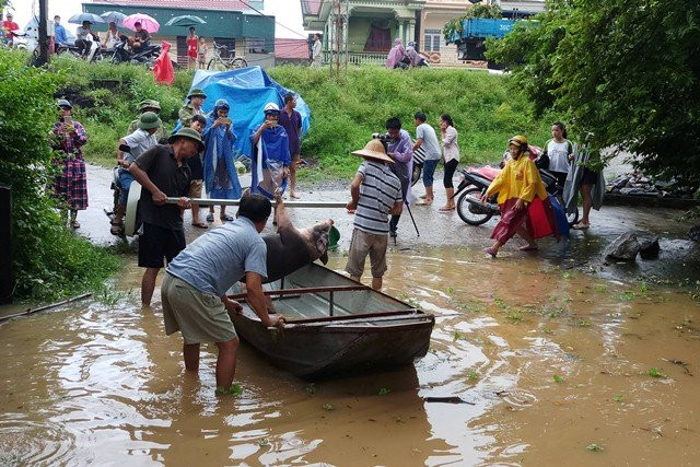 Người dân vận chuyển đồ dùng cần thiết ra khỏi nơi ngập lụt.