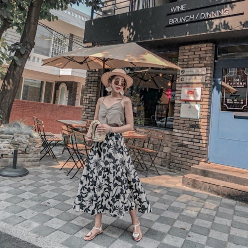 Áo hai dây và chân váy xòe luôn là bộ đôi hoàn hảo được nhiều quý cô lựa chọn trong những ngày hè oi bức. Để set đồ không nhàm chán, bạn có thể phối thêm phụ kiện cơ bản, đặc trưng của mùa hè như mũ cói, kính mắt và sandals đế bệt.
