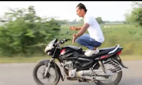 Người đàn ông vừa đi xe máy vừa... tập Yoga