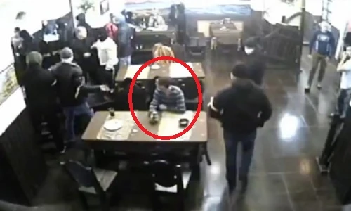 Chàng trai thản nhiên ngồi ăn, xem côn đồ đánh nhau