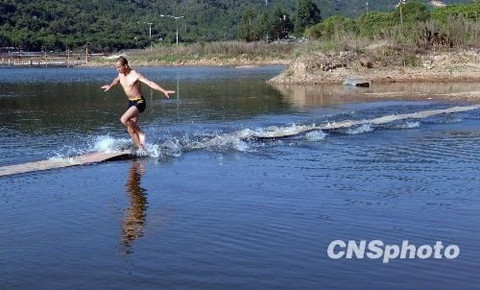 Cũng có khi người ta luyện tập bằng cách đào hố hẹp rồi đứng từ dưới hố nhảy lên. Cứ theo thời gian hố đào sâu dần xuống cho đến khi hố sâu bằng chiều cao người mà vẫn nhảy lên được thì đã thành công phần nào. Trong ảnh là một nhà sư Thiếu Lâm biểu diễn khi công chạy trên mặt nước. Ảnh: CNS.