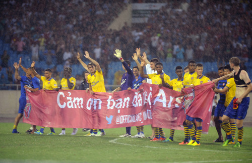 Các cầu thủ Arsenal mang băng rôn cảm ơn khán giả Việt Nam trước khi rời sân Mỹ Đình (Hà Nội) tối 17/7.