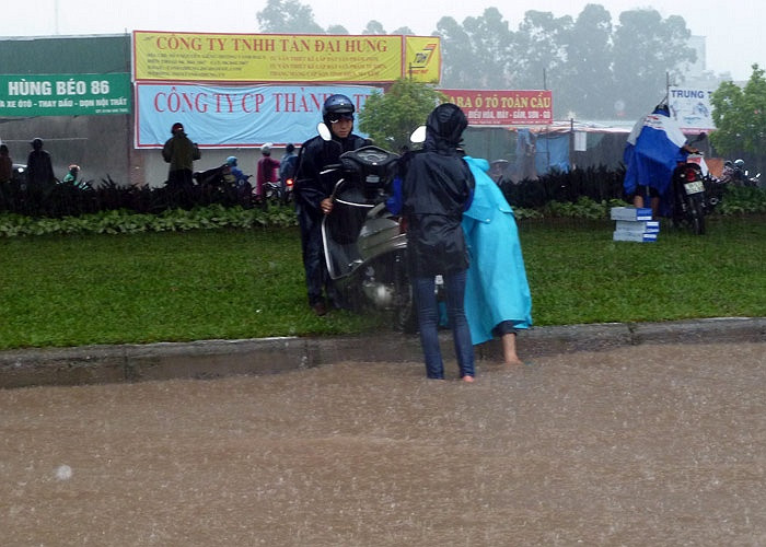 Lúc khó khăn, người dân hỗ trợ nhau cứu xe khỏi nước ngập.