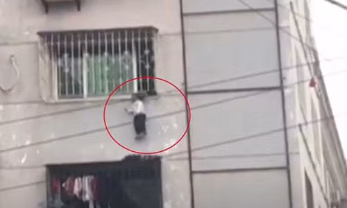 Video: Kẹt đầu vào “chuồng cọp” chung cư, bé trai bị treo lơ lửng giữa trời