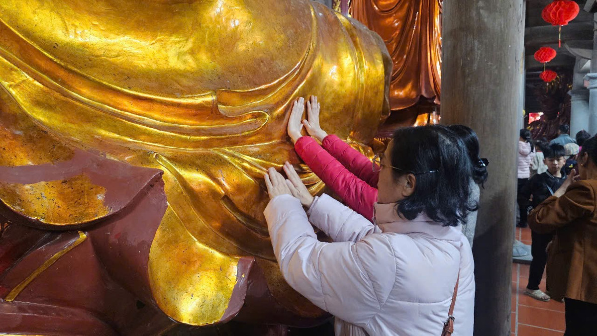 Một số người phụ nữ khác dùng tay đặt lên tượng Phật.