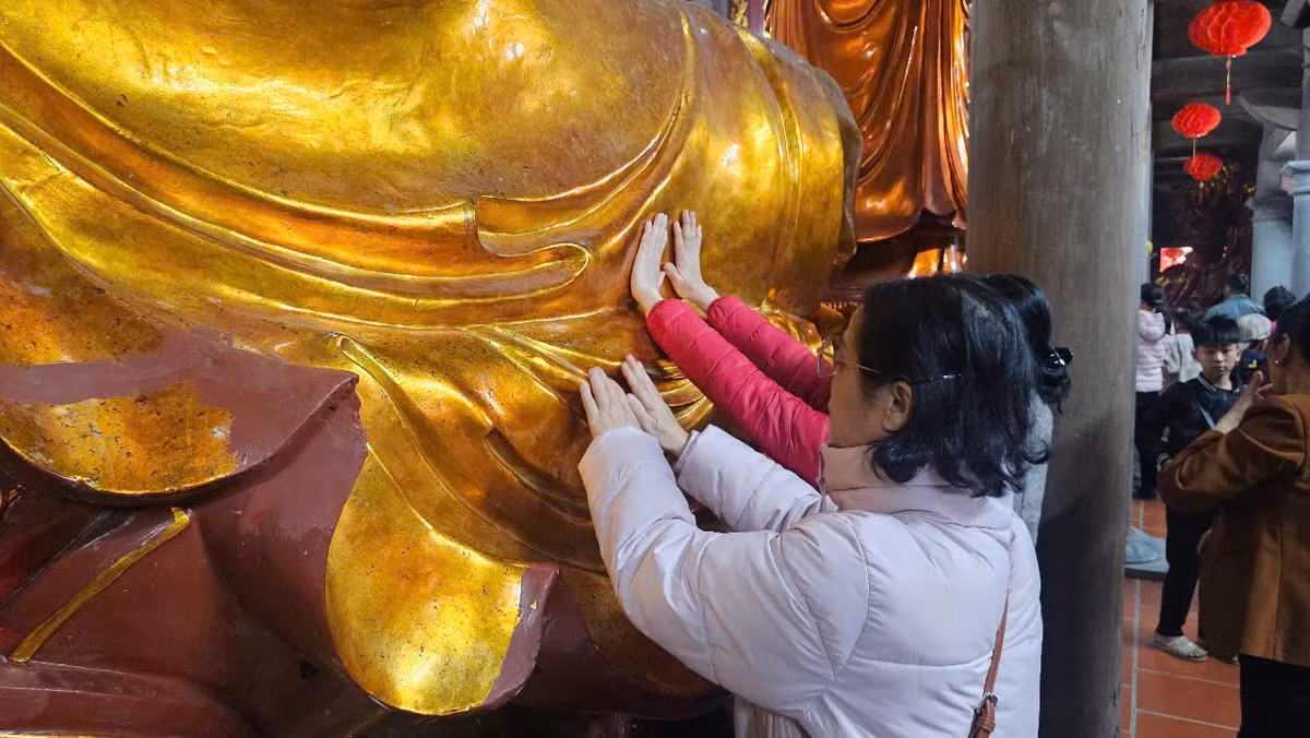 Một số người phụ nữ khác dùng tay đặt lên tượng Phật.
