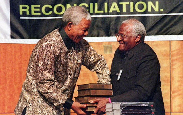Cố Tổng thống Nelson Mandela nhận tập sách của Ủy Ban Chân Lý và Hoà Giải Nam Phi từ tay Tổng giám mục Archbishop Desmond Tutu ngày 29/10/1998 ở Pretoria, Nam Phi.
