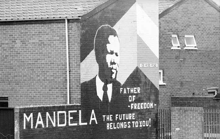 Thông điệp hòa bình của cố Tổng thống Nelson Mandela không chỉ phổ biến rộng rãi ở Nam Phi mà còn vươn ra toàn thế giới khi chân dung của ông được vẽ trên tường ở nhiều nơi. Trong ảnh là chân dung tại một ngôi nhà ở Bắc Ireland năm 1995.