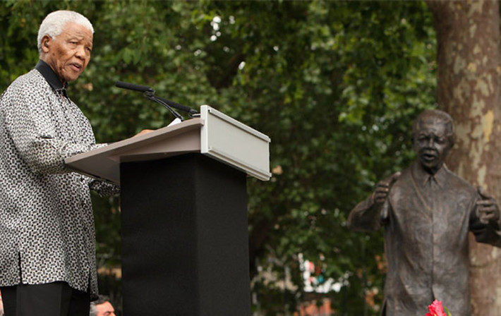 Cố Tổng thống Nelson Mandela phát biểu ở London, Anh ngày 29/8/2007. Bức tượng của ông được đặt gần đó.