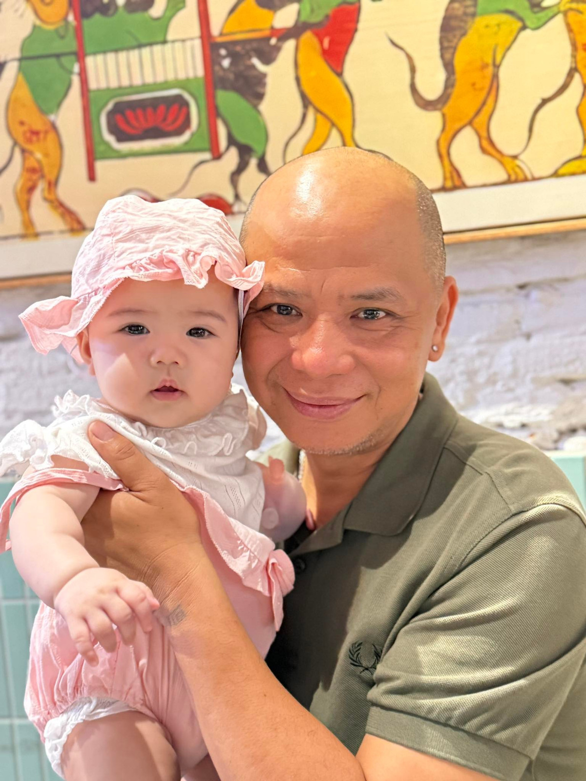 Diễn viên Anh Tuấn cưng nựng cháu ngoại. Ảnh: FB Nguyệt Hằng Cao