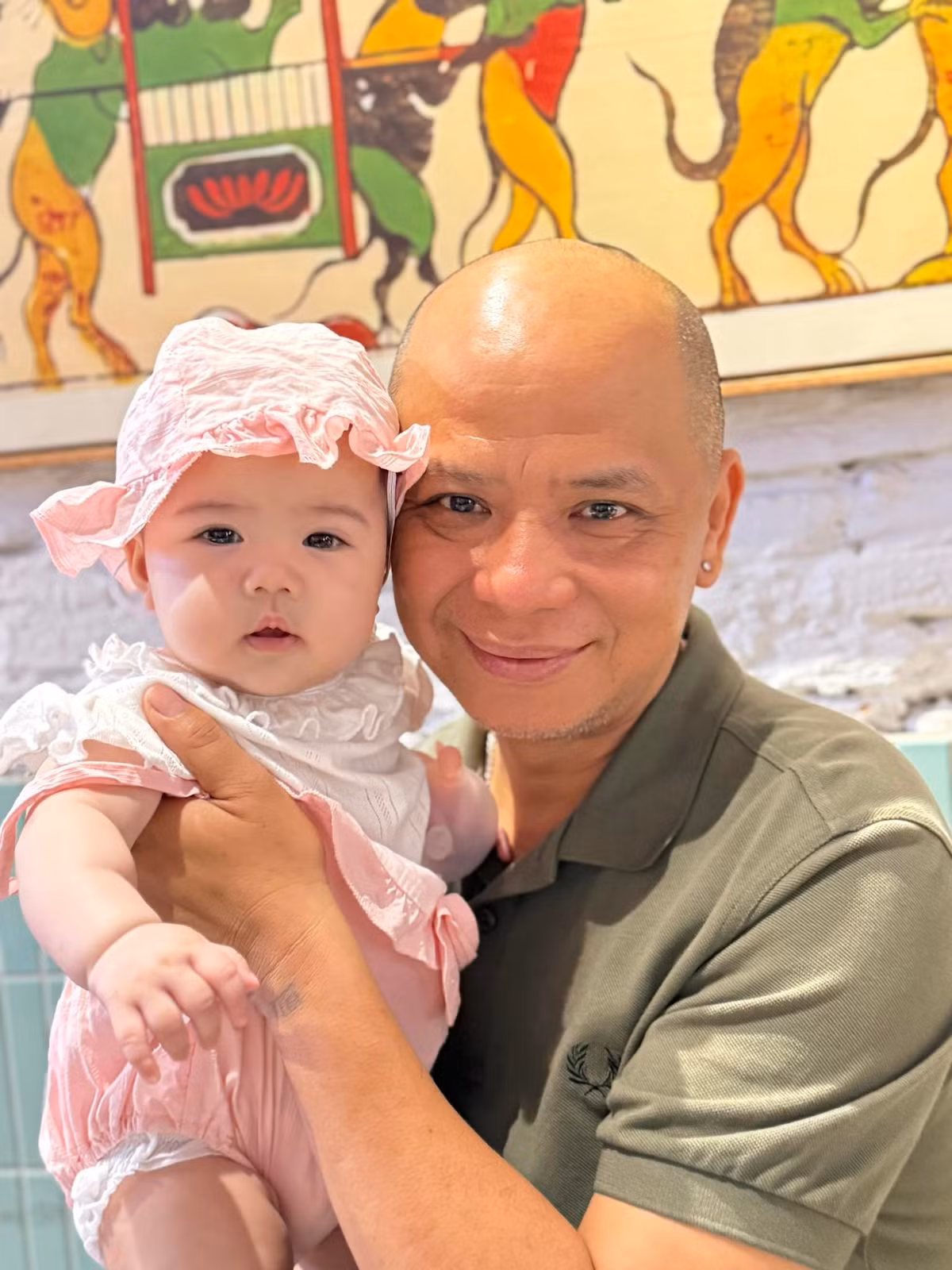 Diễn viên Anh Tuấn cưng nựng cháu ngoại. Ảnh: FB Nguyệt Hằng Cao