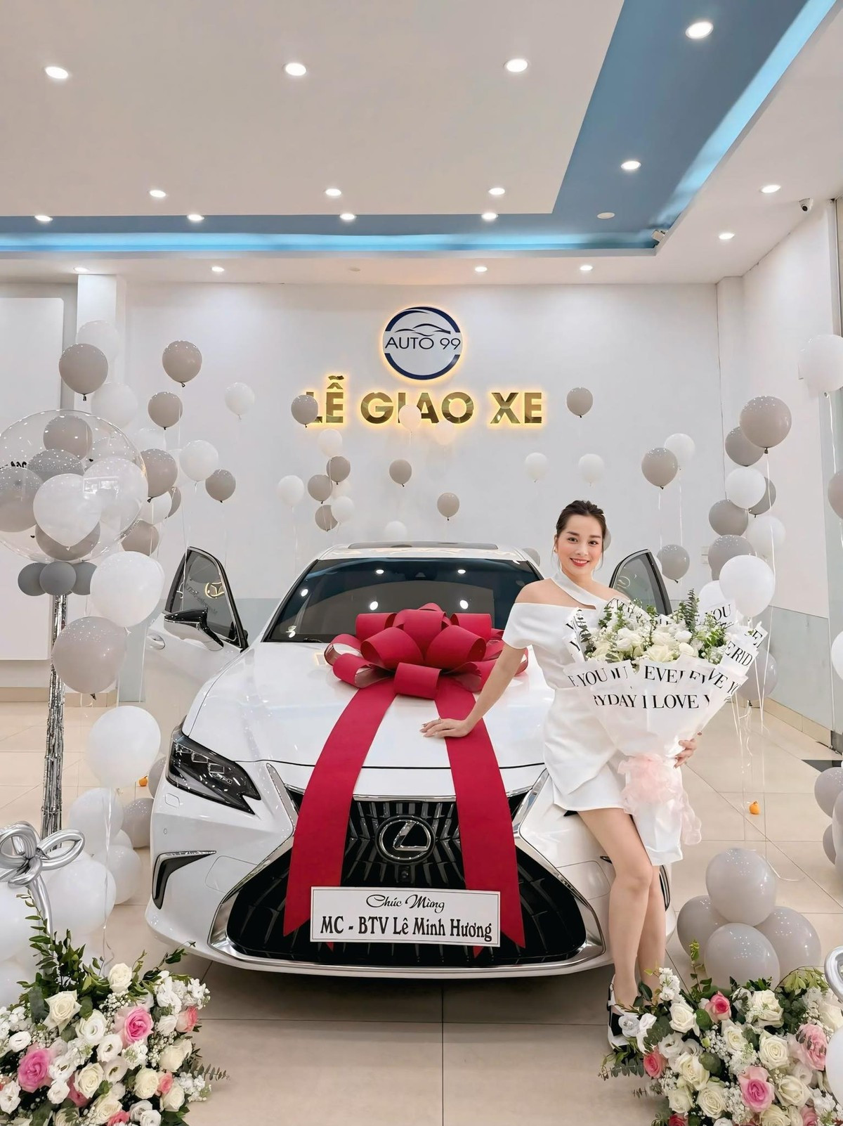 Minh Hương diện váy trắng và đứng tạo dáng bên xe mới tậu.