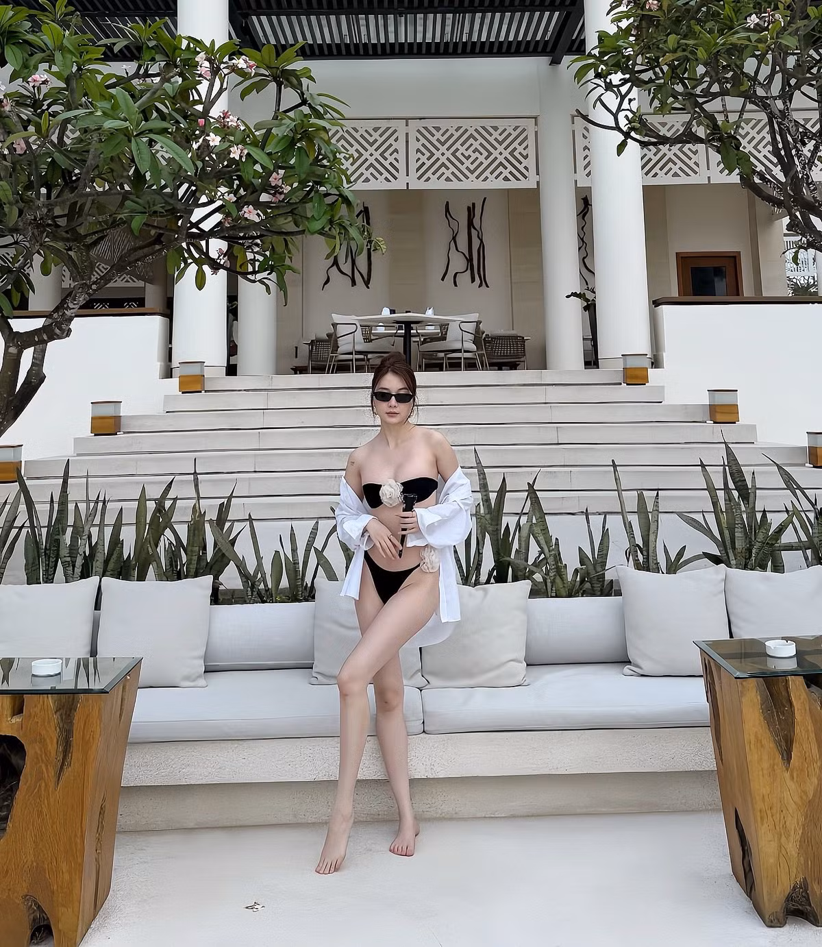 Ca sĩ Thiều Bảo Trang diện bikini 2 mảnh siêu nhỏ, màu đen, nổi bật với chi tiết bông hoa trắng trước ngực. Ảnh: FB Thiều Bảo Trang