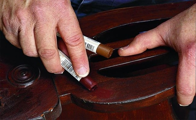 Sử dụng sáp màu hoặc bút màu cùng tone gỗ là giải pháp nhanh gọn cho các vết xước nhẹ trên bề mặt. Bạn chỉ cần chọn sáp hoặc bút màu có tone tương đồng với màu sàn, chà trực tiếp lên vết xước rồi lau sạch phần dư bằng khăn mềm. Cách này giúp che phủ vết trầy và làm sàn trông đều màu hơn.