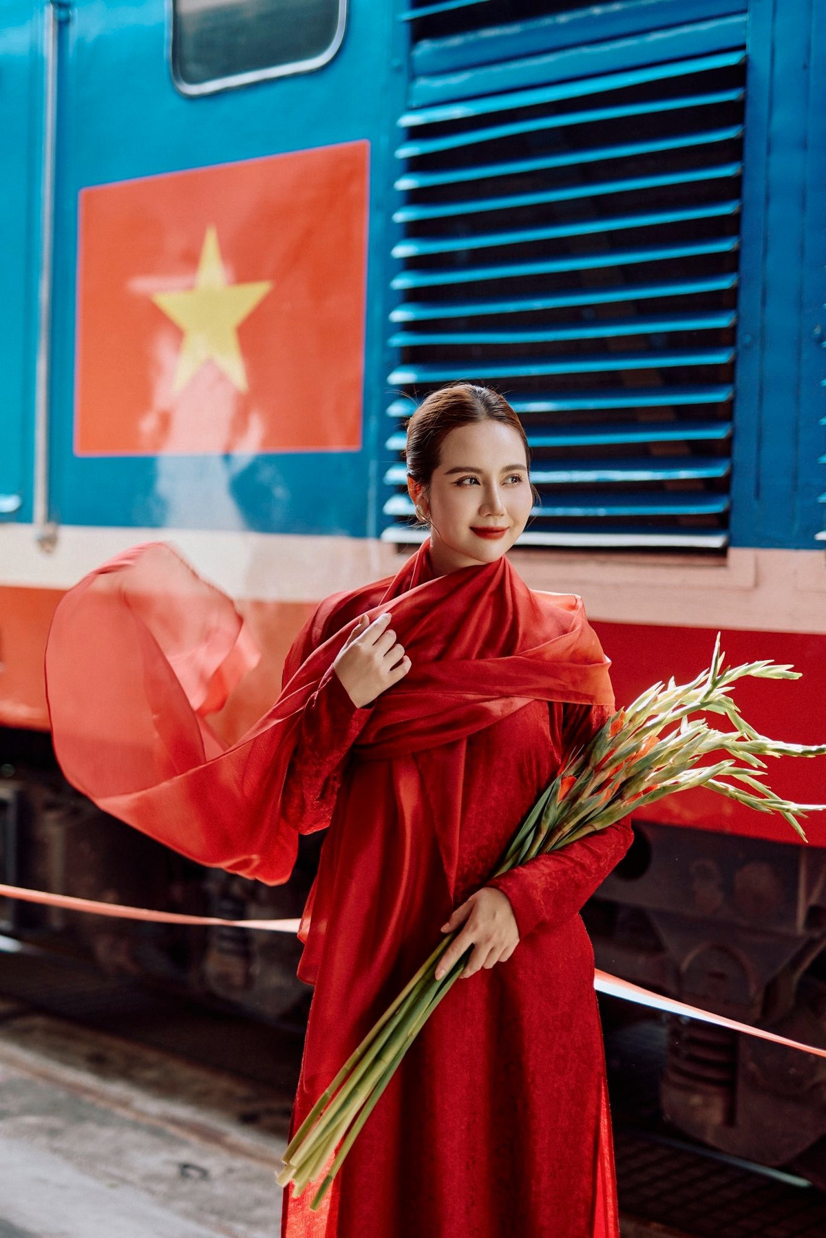 Tin tức sao Việt 28/8: Huyền Lizzie gây chú ý khi đăng tải bộ ảnh áo dài đỏ rực rỡ kết hợp khăn choàng đỏ mang đậm tinh thần tự hào dân tộc. Ảnh: FB Phan Minh Huyền