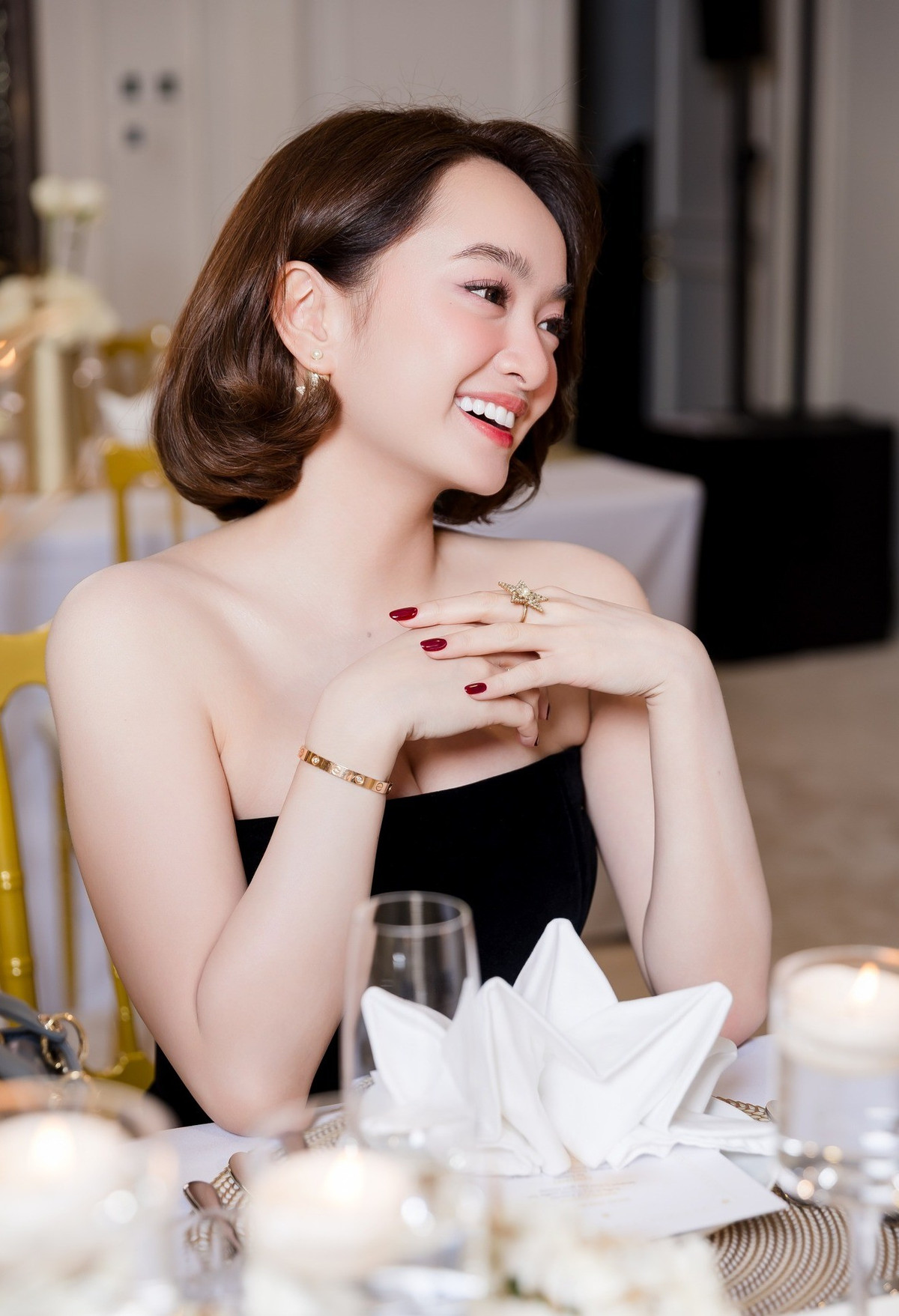 Cô thường lựa chọn những trang phục như áo hai dây, áo cổ yếm, váy liền nhẹ nhàng hoặc sơ mi kết hợp quần ống rộng. Những kiểu trang phục này giúp tôn lên vẻ ngoài trẻ trung, năng động nhưng vẫn toát lên thần thái sang trọng.