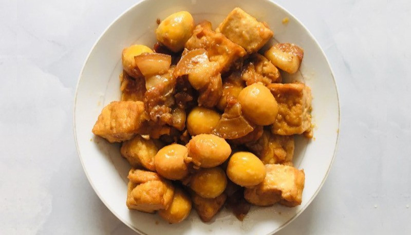 Cuối cùng, không thể bỏ qua đậu phụ kho trứng cút – món ăn quen thuộc nhưng luôn được yêu thích. Trứng cút luộc bóc vỏ, chiên sơ cùng đậu rồi kho chung với nước mắm, đường và tiêu. Khi nước kho sánh lại, cả đậu lẫn trứng đều thấm vị, béo bùi và cực kỳ đưa cơm.