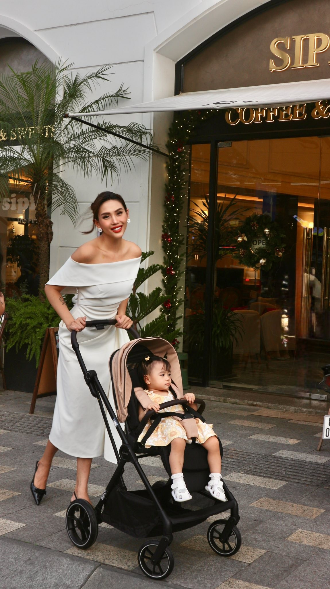 Siêu mẫu Võ Hoàng Yến đẩy xe nôi đưa con gái đi uống trà chiều. Ảnh: FB Võ Hoàng Yến