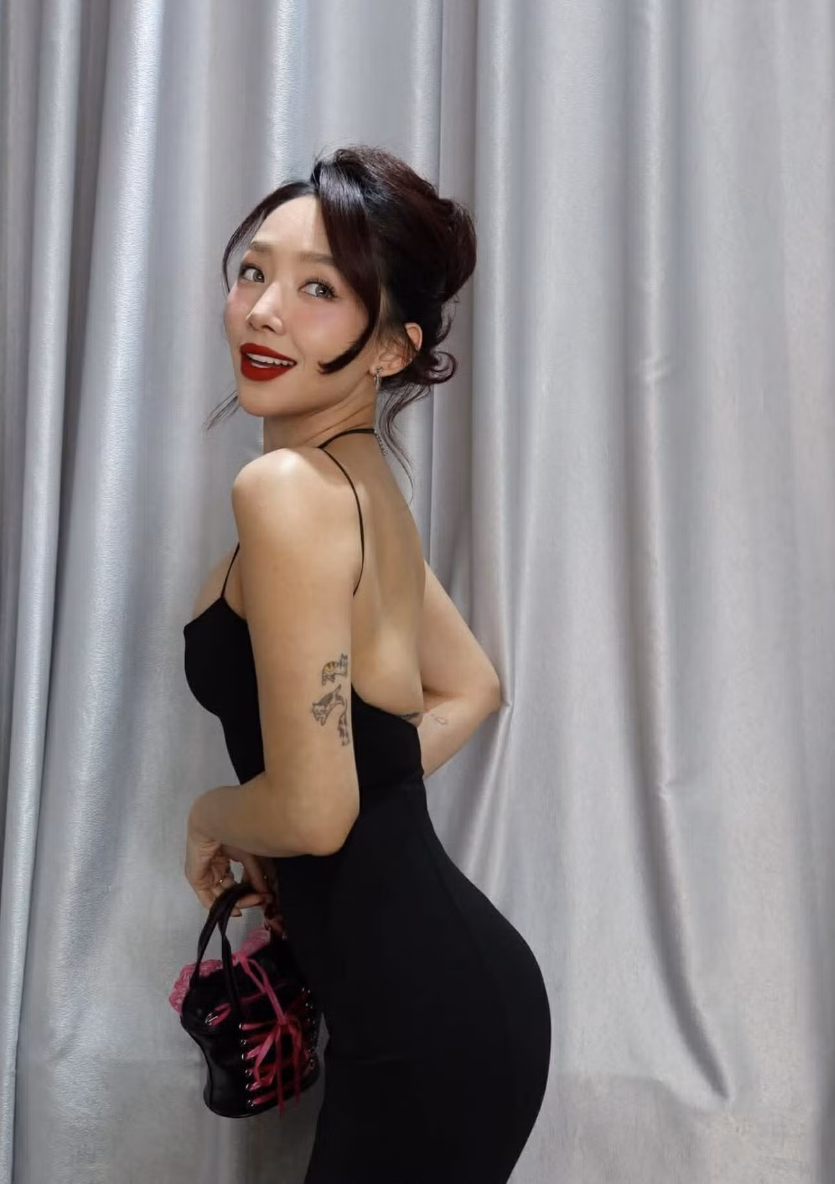 Nữ ca sĩ lựa chọn chiếc đầm đen hai dây có thiết kế hở bạo, khoe bờ vai thon, vòng eo gọn gàng, tấm lưng trần cùng đường cong cơ thể đầy cuốn hút.