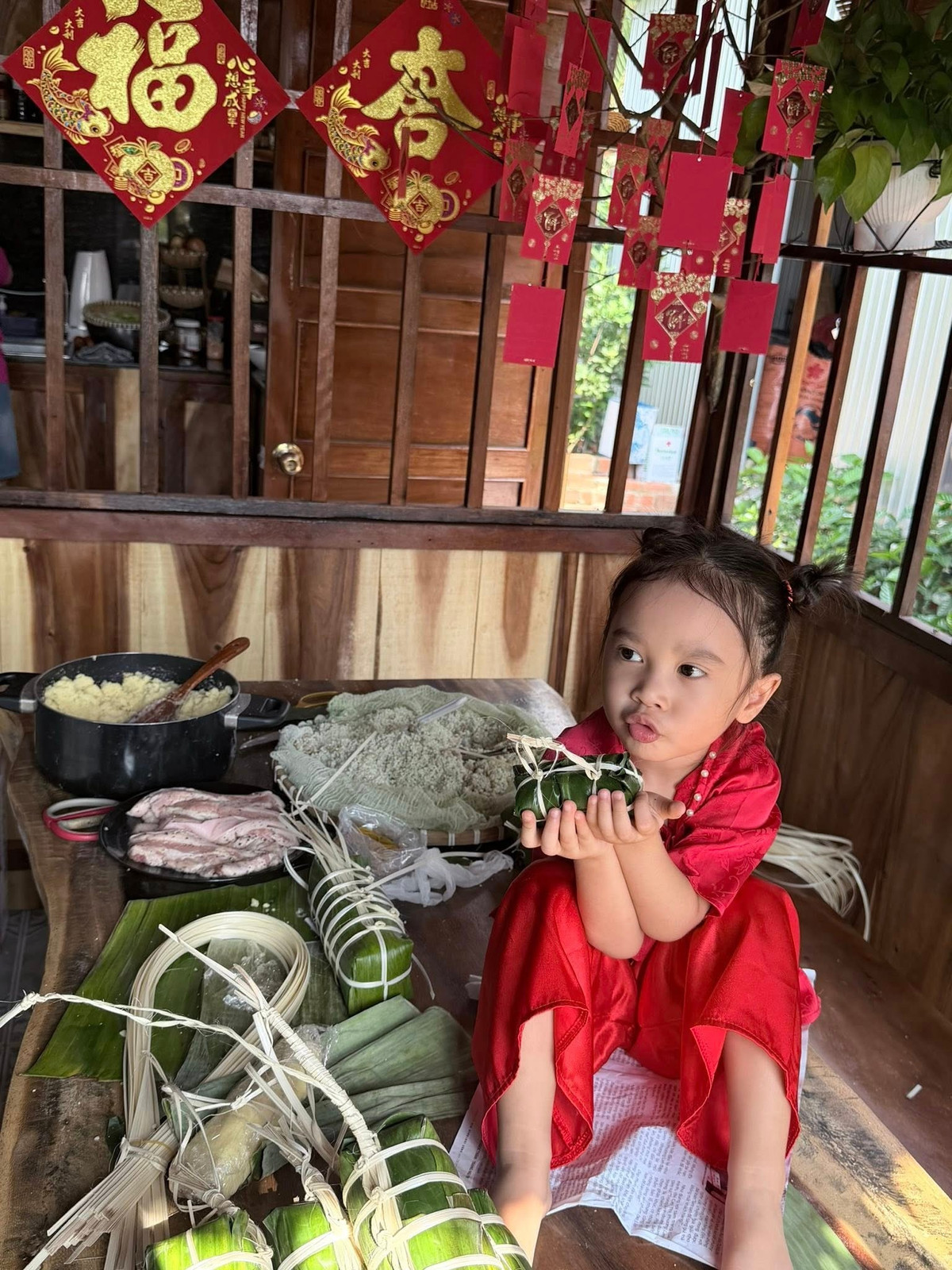 Ca sĩ Bảo Anh khoe khoảnh khắc đáng yêu của con gái chụp ảnh bên bánh tét tự làm. Ảnh: FB Bảo Anh