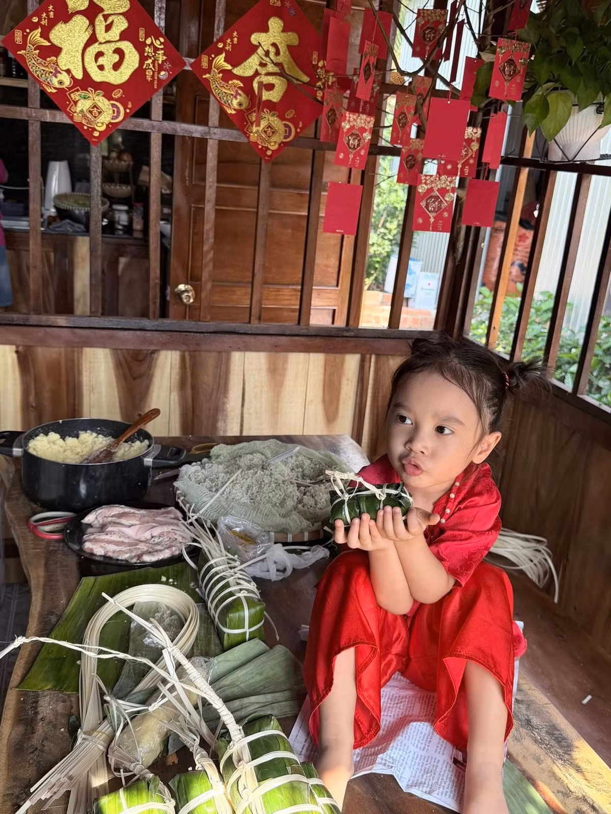 Ca sĩ Bảo Anh khoe khoảnh khắc đáng yêu của con gái chụp ảnh bên bánh tét tự làm. Ảnh: FB Bảo Anh