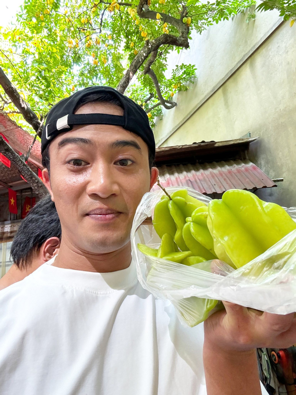 Diễn viên Doãn Quốc Đam khoe được tặng khế trên phim trường. Ảnh: FB Danny Yin