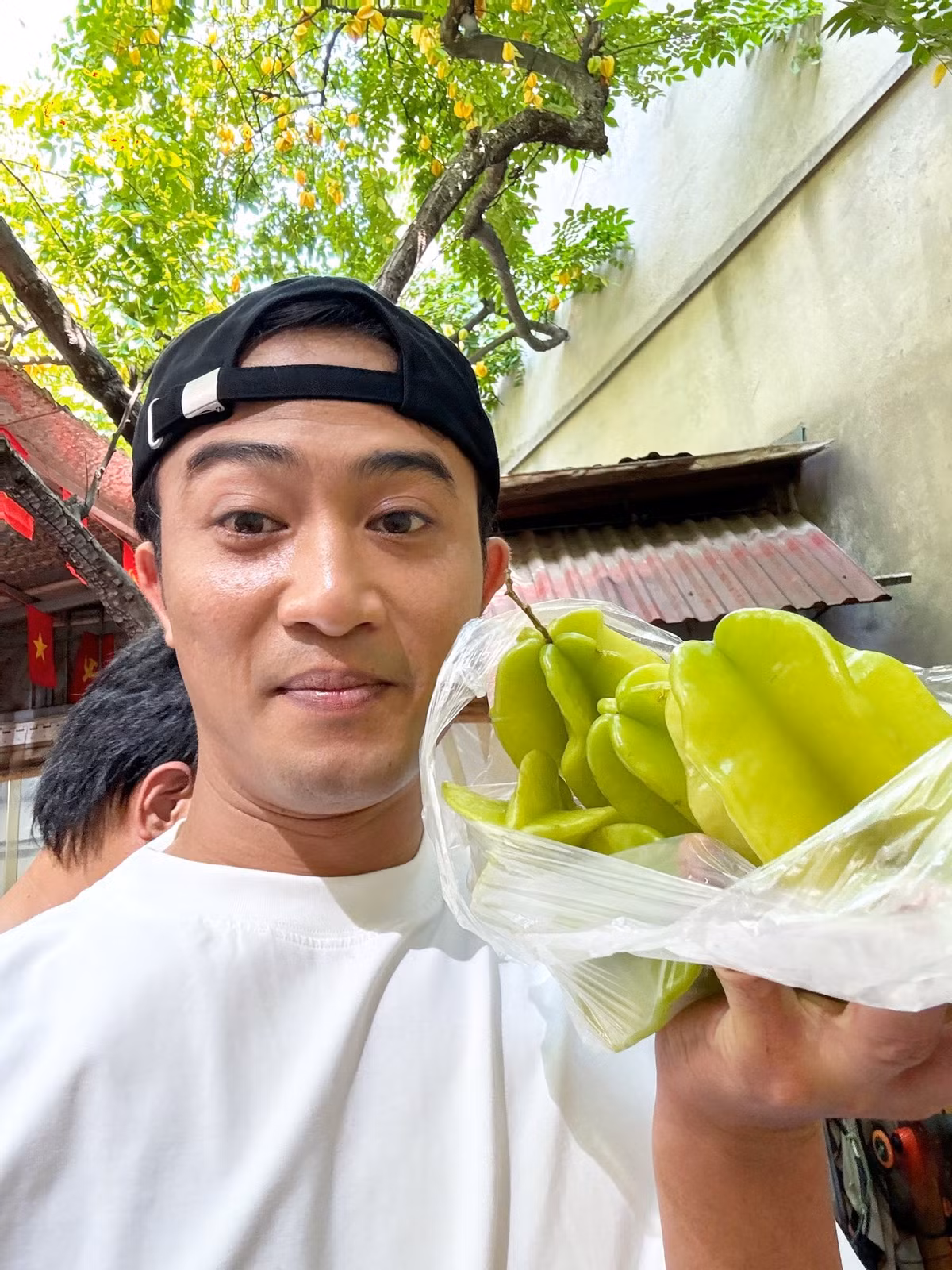 Diễn viên Doãn Quốc Đam khoe được tặng khế trên phim trường. Ảnh: FB Danny Yin