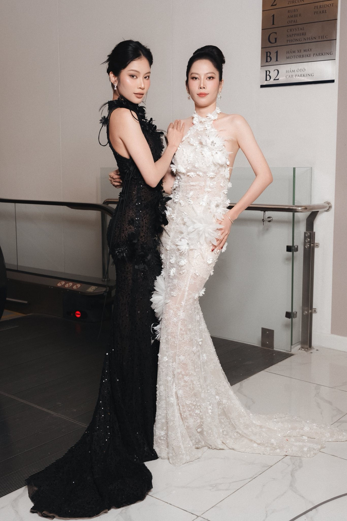 Chị em sinh đôi Nam Anh - Nam Em diện đầm cổ yếm hở lưng dự sự kiện. Ảnh: FB Nguyễn Lệ Nam Anh