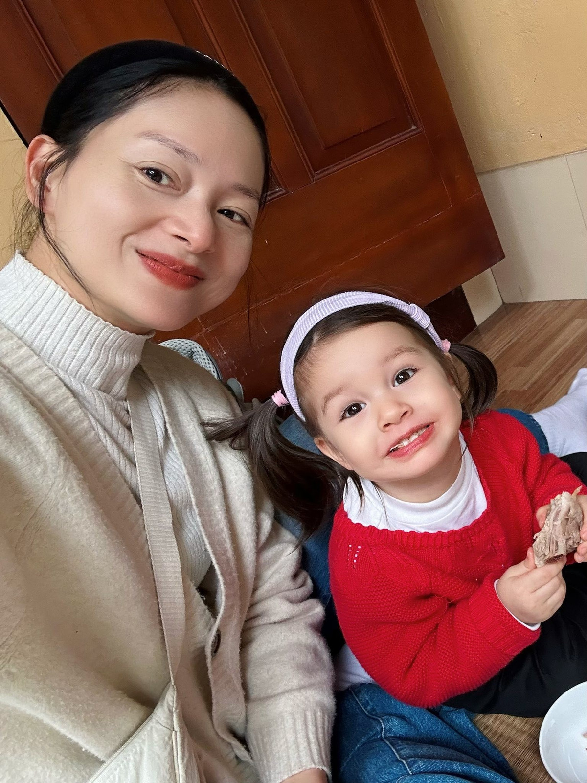 Diễn viên đưa con gái Mia về quê ăn giỗ. Em bé lai Tây tỏ ra thích thú khi được ngồi chiếu, gặm đùi gà. Ảnh: FB Lan Phuong Nguyen