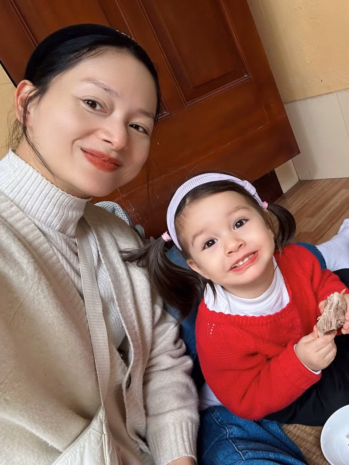 Diễn viên đưa con gái Mia về quê ăn giỗ. Em bé lai Tây tỏ ra thích thú khi được ngồi chiếu, gặm đùi gà. Ảnh: FB Lan Phuong Nguyen