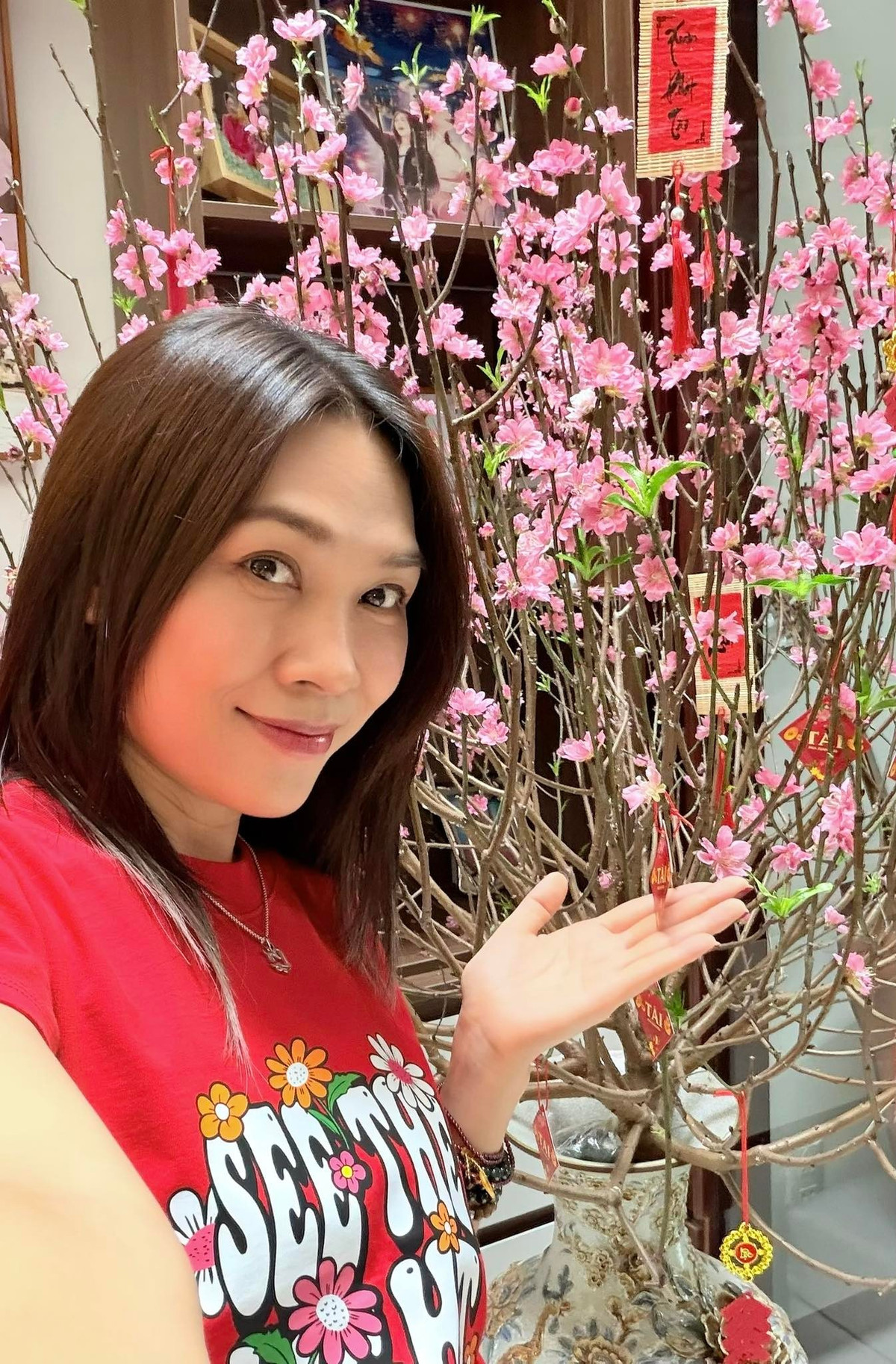 Ca sĩ Mỹ Tâm chụp ảnh bên cành đào nở rộ. Ảnh: FB My Tam