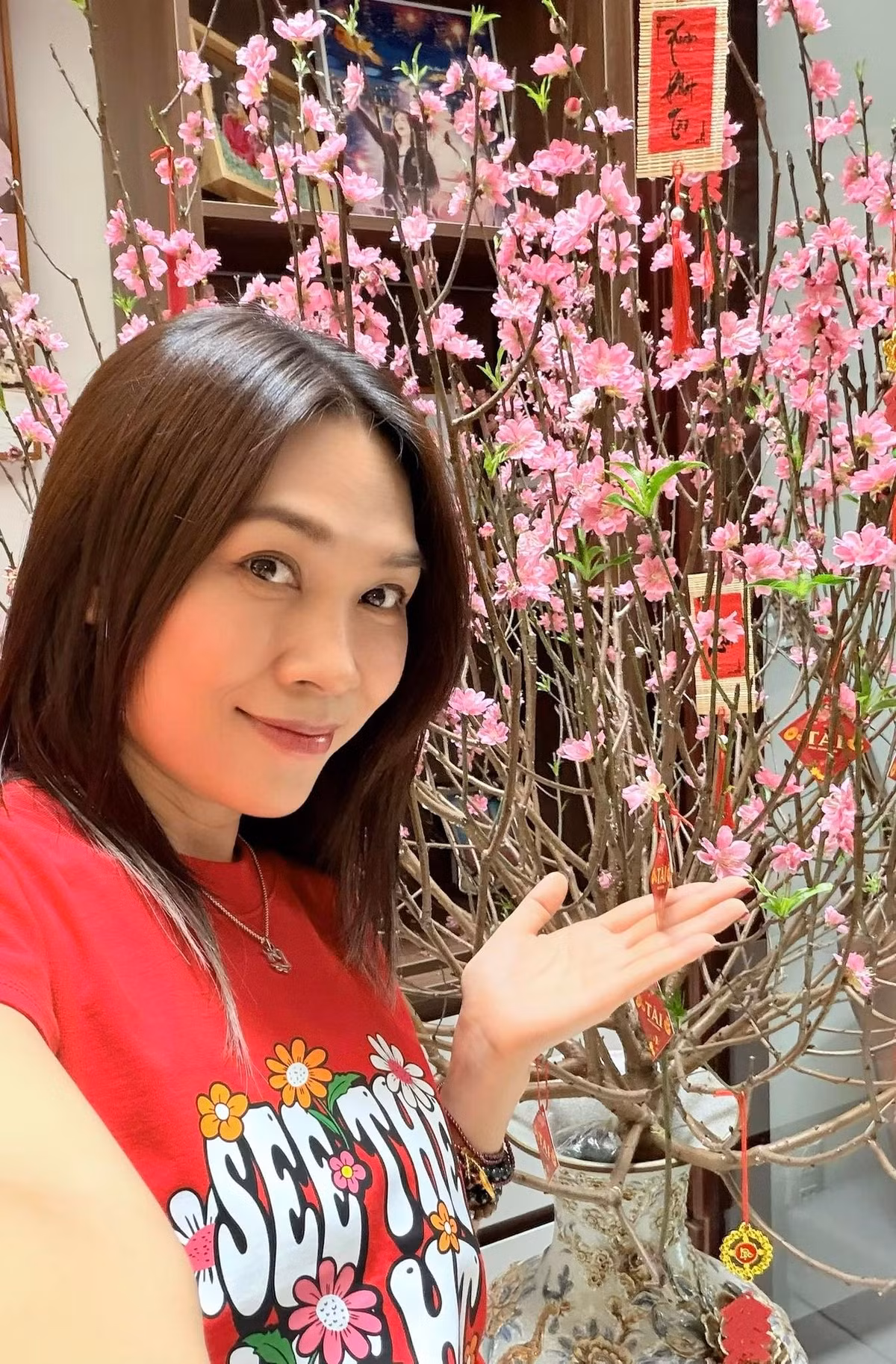 Ca sĩ Mỹ Tâm chụp ảnh bên cành đào nở rộ. Ảnh: FB My Tam