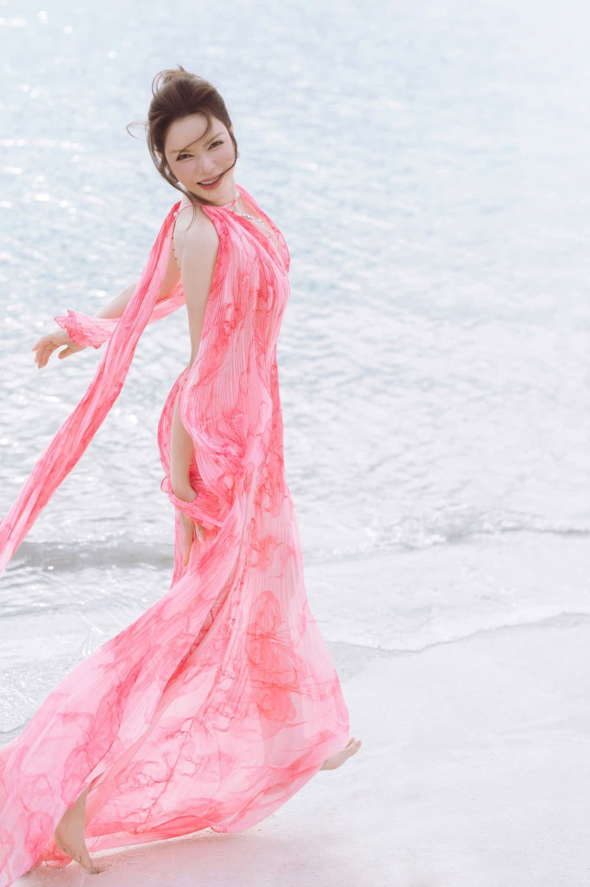 Diễn viên diện bộ cánh thướt tha, thiết kế xẻ vạt cao, hở trọn lưng trần, dạo chơi trên bãi biển. Ảnh: FB Ly Nha Ky