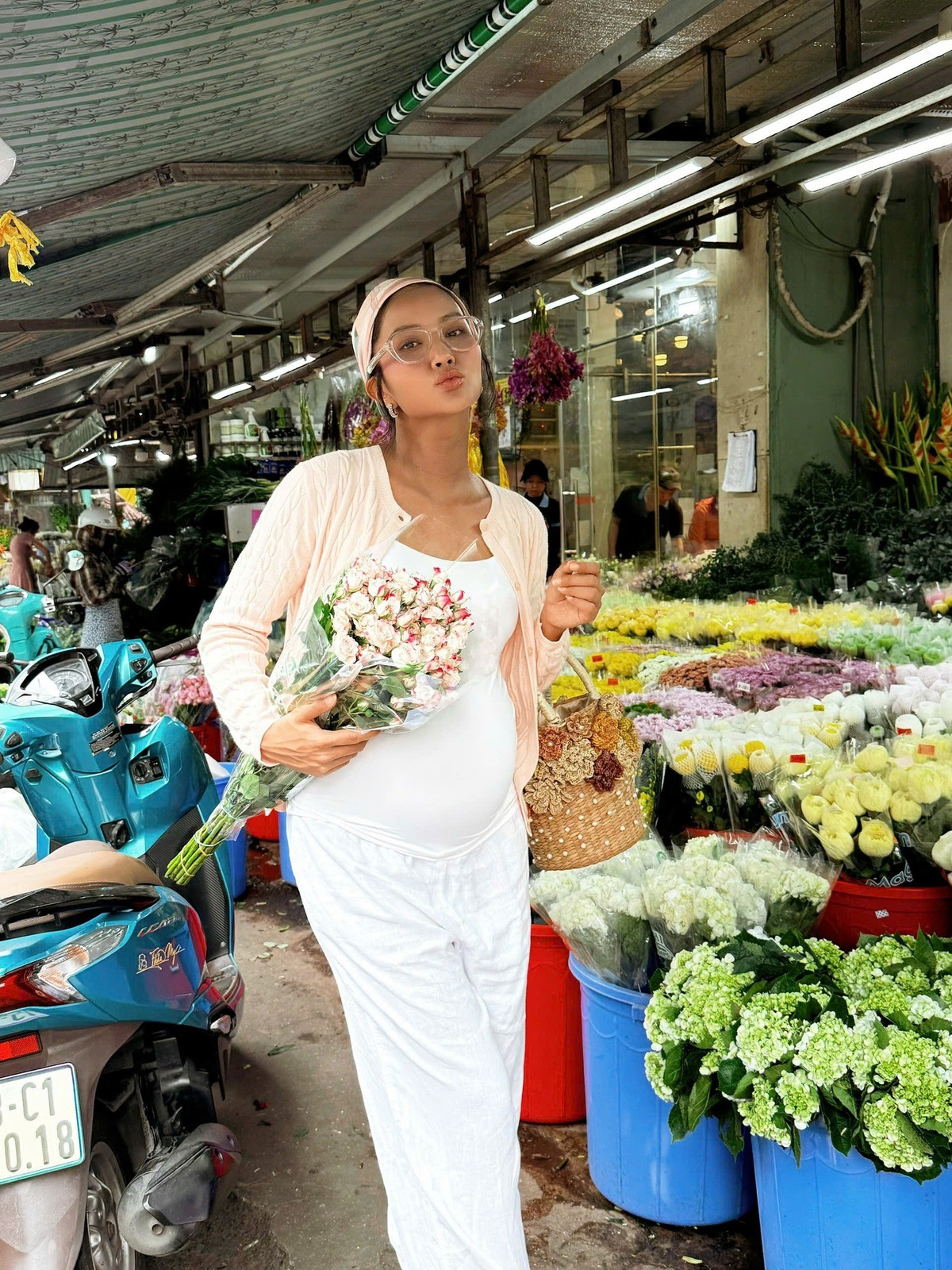 Hoa hậu H'Hen Niê "bế" bụng bầu đi mua hoa tươi. Ảnh: FB H'Hen Niê