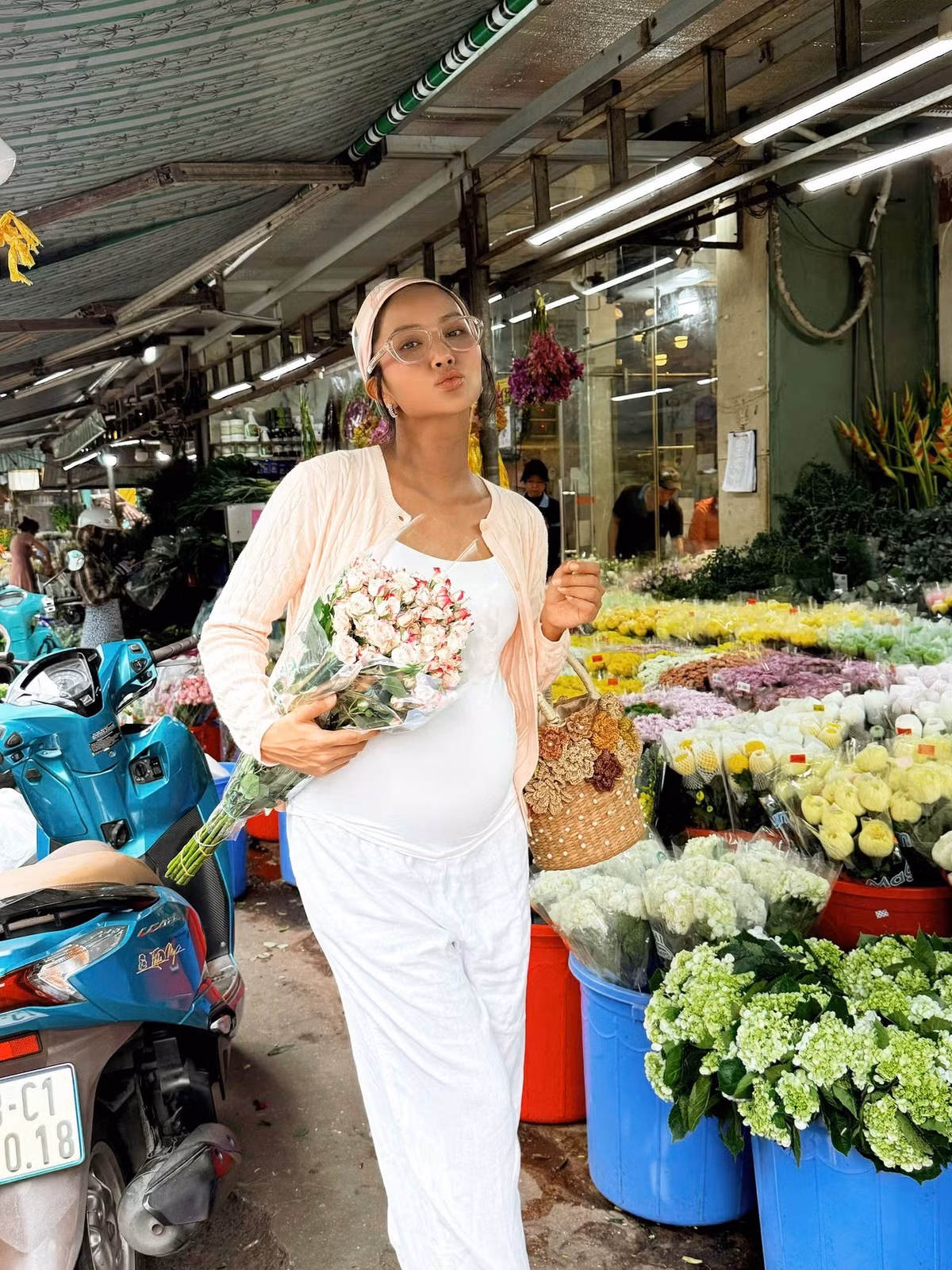 Hoa hậu H'Hen Niê "bế" bụng bầu đi mua hoa tươi. Ảnh: FB H'Hen Niê