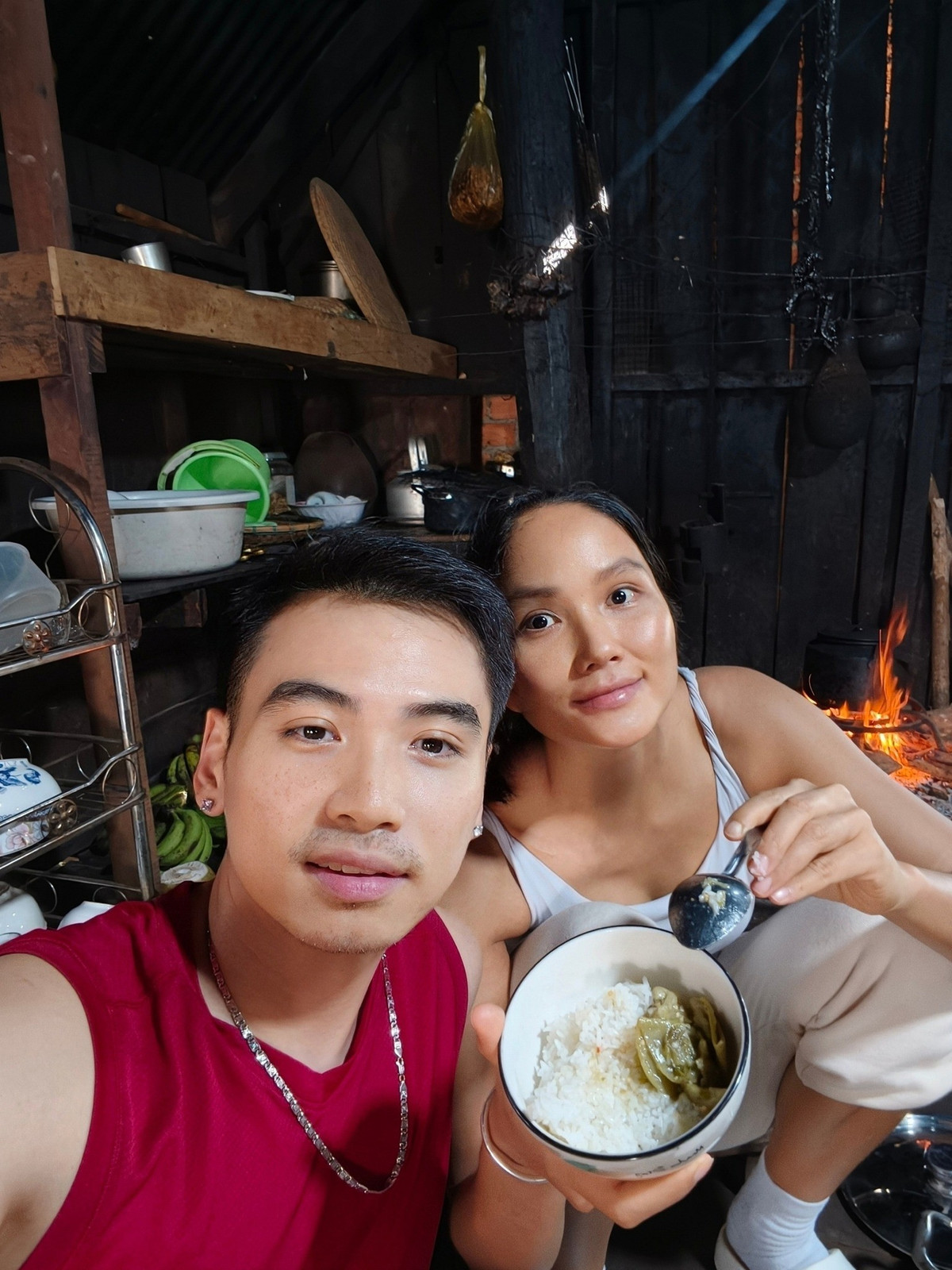 Nhiếp ảnh Tuấn Khôi đăng khoảnh khắc H'Hen Niê mặt mộc, ăn mặc tuềnh toàng, ăn cơm bên bếp lửa. Ảnh: FB Tuấn Khôi