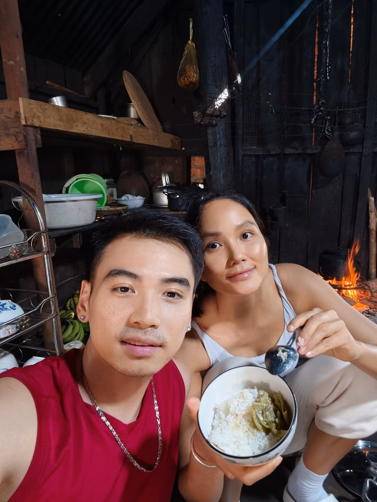 Nhiếp ảnh Tuấn Khôi đăng khoảnh khắc H'Hen Niê mặt mộc, ăn mặc tuềnh toàng, ăn cơm bên bếp lửa. Ảnh: FB Tuấn Khôi