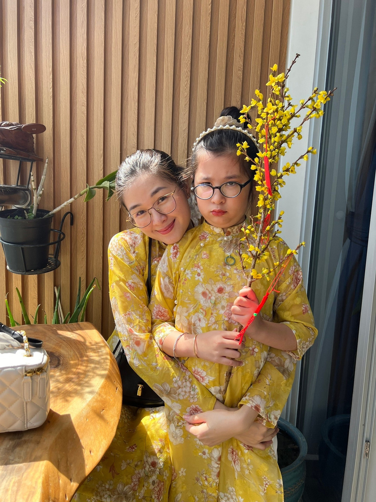 Mạc Anh Thư và bé Cát diện áo dài, sắm cành mai chuẩn bị đón Tết. Ảnh: FB Mạc Anh Thư