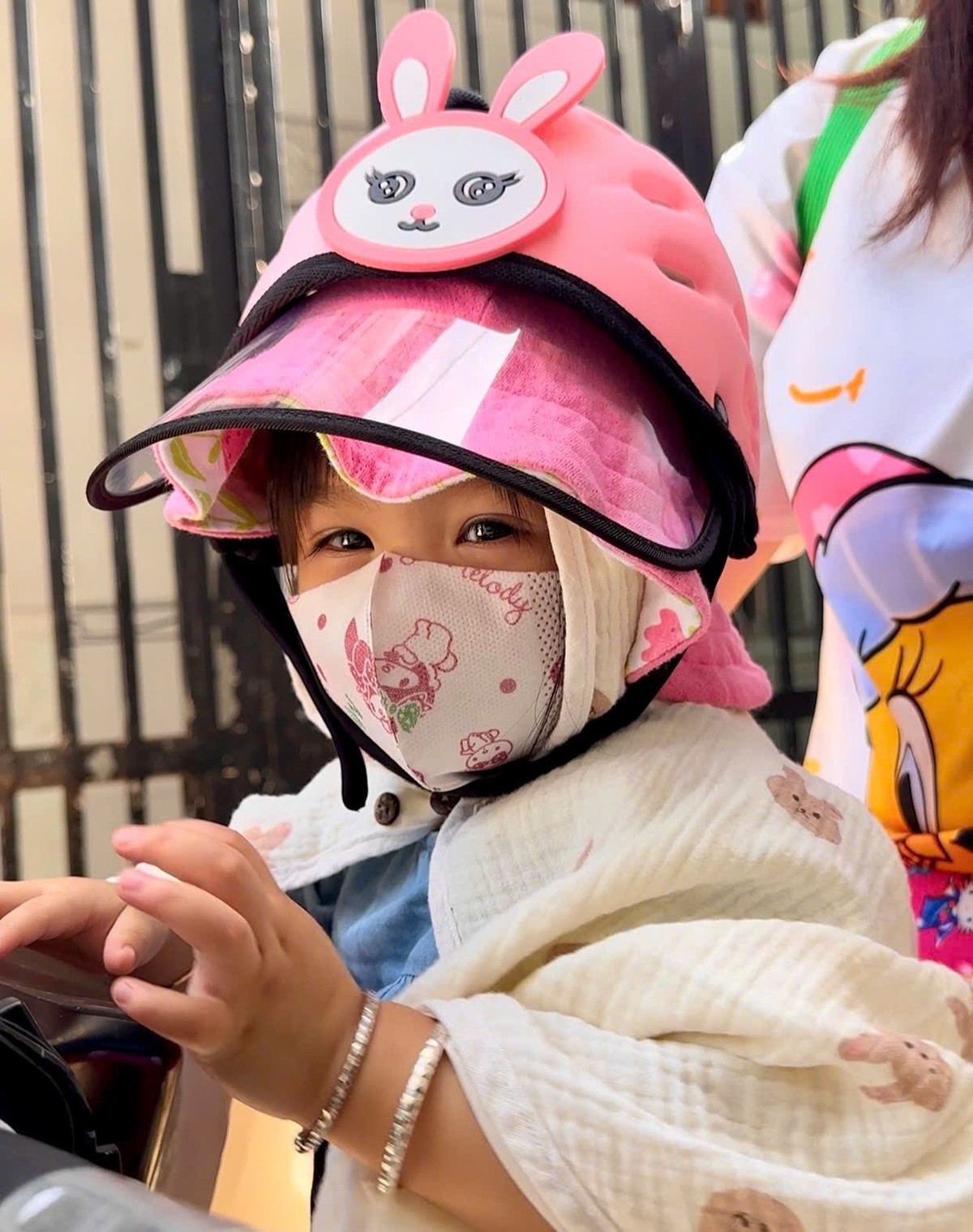 Diễn viên Kha Ly trùm kín mít cho con gái Lita khi đưa bé đi học bằng xe máy. Ảnh: FB Lại Thị Kha Ly