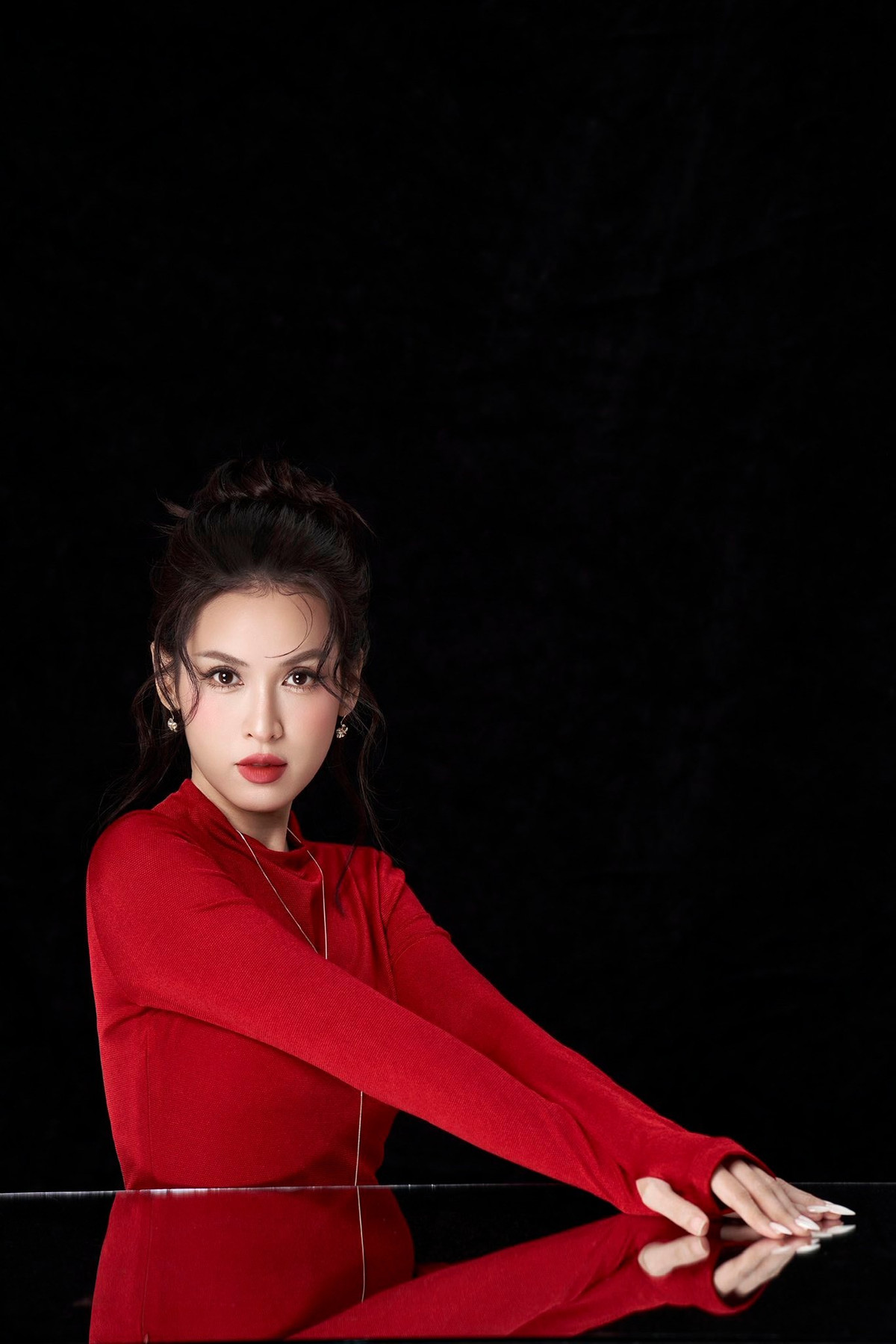 Chiếc đầm đỏ rực ôm dáng tôn lên đường cong mềm mại, trong khi layout trang điểm sắc sảo giúp gương mặt của cô thêm nổi bật.