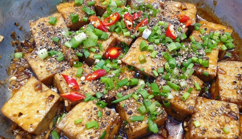 Tiếp theo, với những ai yêu thích vị cay nồng nhẹ, đậu phụ kho tiêu chắc chắn là gợi ý đáng thử. Khi kho ở lửa nhỏ, đậu thấm đều gia vị và dậy mùi tiêu xay thơm lừng. Món ăn giản dị nhưng lại mang đến cảm giác ấm áp, rất thích hợp cho những bữa cơm ngày se lạnh.